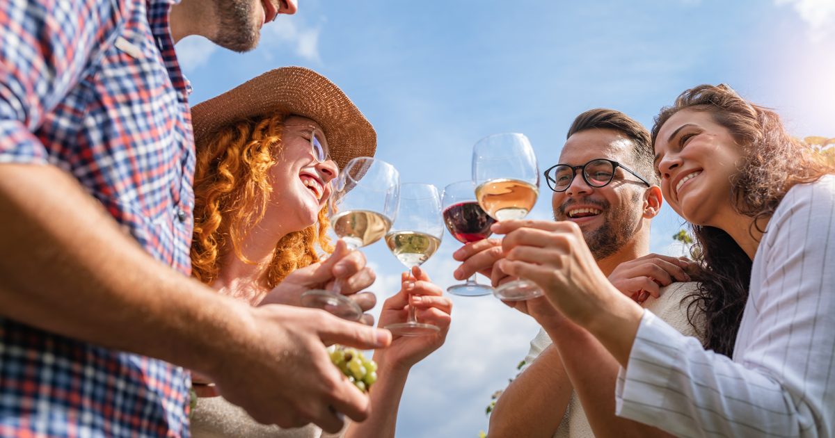 Happy friends having fun drinking wine